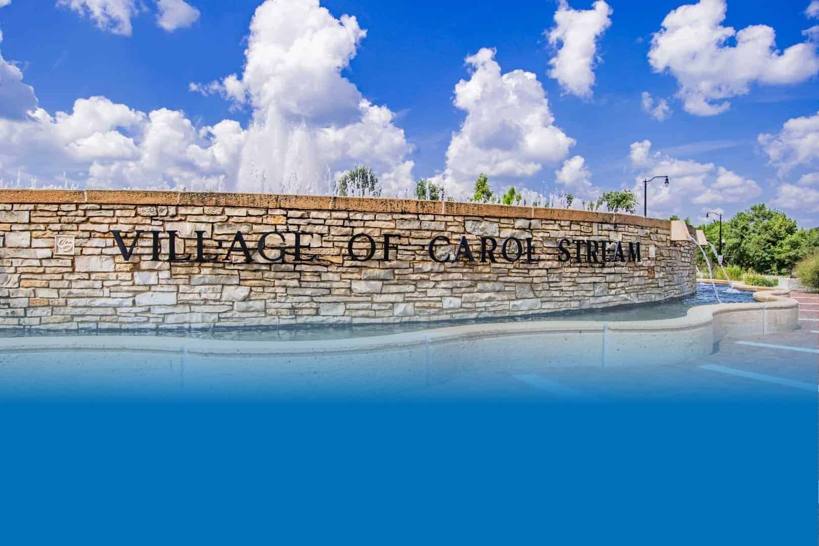 Welcome to the Village of Carol Stream, Illinois - community sign with water feature on a bright, sunny day.